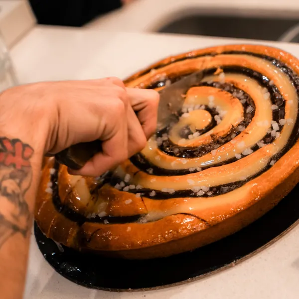 Cinnamon swirl cake being cut at the bar